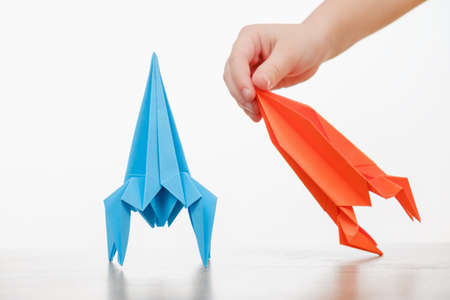 Happy child boy playing with handmade origami paper rocketの写真素材