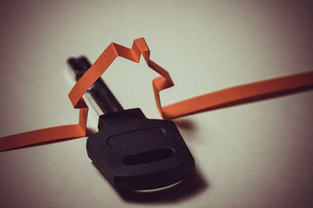 Concept of housing construction, paper abstract house with key symbol. Insurance of real estate.の写真素材