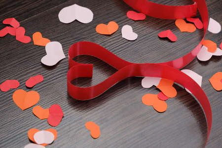 Valentine's Day background with ribbon hearts on wood abstract backdrop.の写真素材