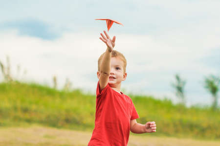 Young boy very happy with his small aircraft. Country rest on a meadowの写真素材