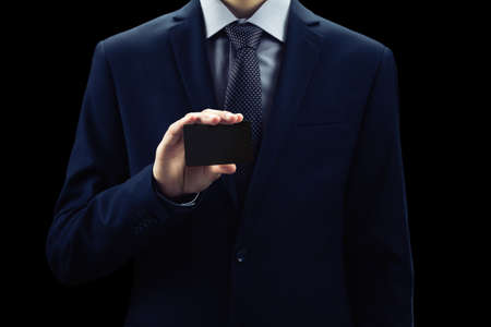 businessman showing empty card on black backgroundの写真素材