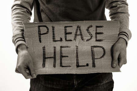 Homeless poor man holding carton board with word Please help for donationsの写真素材