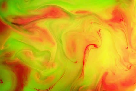 Color Liquid in dynamic flow forming interesting and unique shapes and bubbles. Colorful red green yellow ink mixing in an unique pattern. Artistic design. Isolated on white background.の写真素材