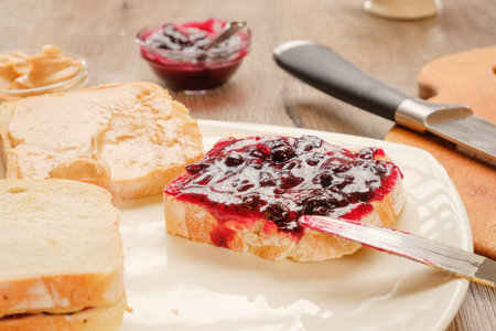 peanut butter sandwich with jam. Cutting board, Kitchen knife.