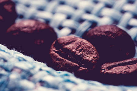 roasted, fragrant coffee grains macro delicious beverage on blue backgroundの写真素材