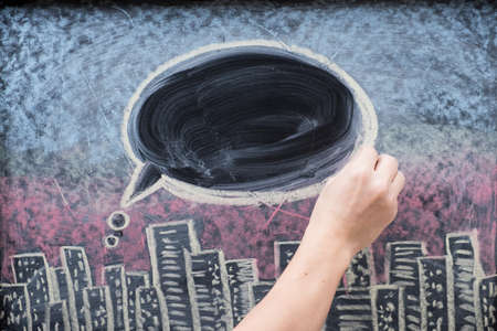 City at night on chalkboard, text balloon or bubble drawn with hand on blackboard textureの写真素材