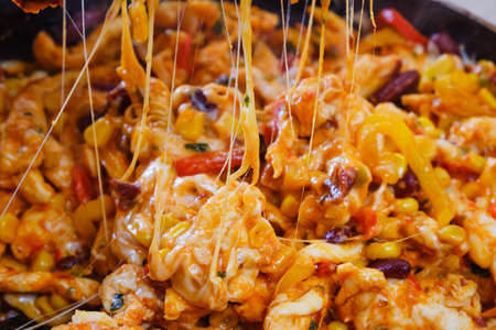 Pan with roasted vegetables, chicken and melted cheese for burritos close-up of cooking burrito food for dinner.の写真素材