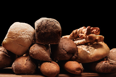 Fresh fragrant bread on the table. Food concept Wheat pastry on black background