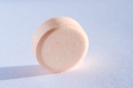 Pink Pill tablet medicine lying isolated on white background extreme close-up macro.