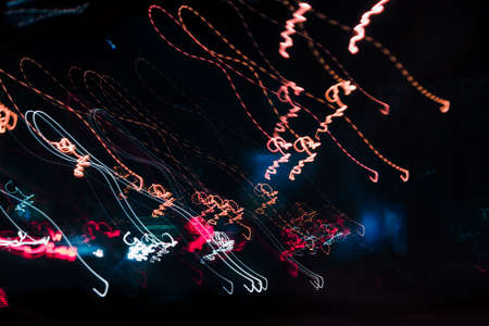 abstract background blurred colored marks from fast moving cars night road. Motion multicolored bokeh.の写真素材