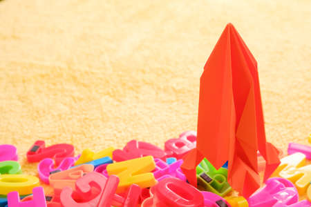 Colorful alphabet letters with red toy origami rocket. Educational conceptの写真素材