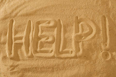 Help Sign text on the beach. Sos symbol concept.の写真素材