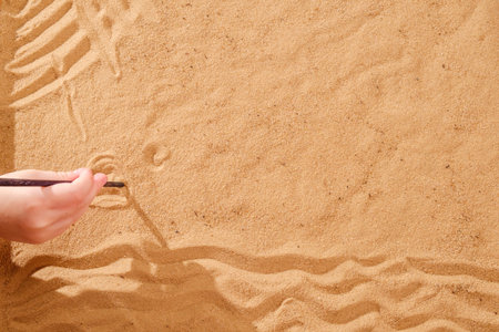 Sand art therapy, child's hands are painted on a table with sand