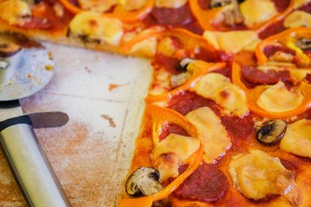 Cutting pepperoni pizza on slices with special knife.