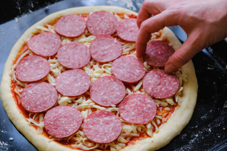Fresh original Italian raw pizza, preparation in traditional style on a baking tray in the ovenの写真素材