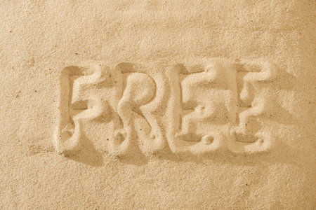 free handwritten text in sand on a beach concept