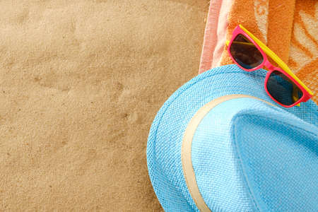 Top view of sandy beach with towel frame and summer accessories. Background with copy space and visible sand texture and towelの写真素材