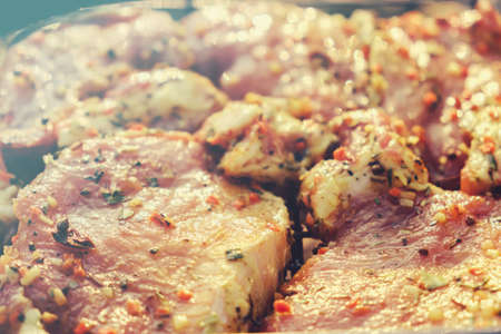 Fresh raw pork neck for steak with herb spices on a barbecue grill. Beef meat steaks.の写真素材