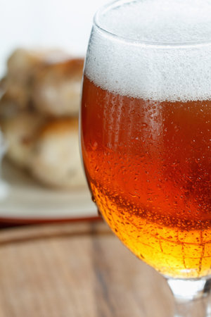 Traditional homemade coiled sausage with beer on wooden table