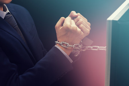 Hands of caucasian businessman addicted to internet and locked with iron chain wrists in smartphone internet addiction and slave to online network addict conceptの写真素材
