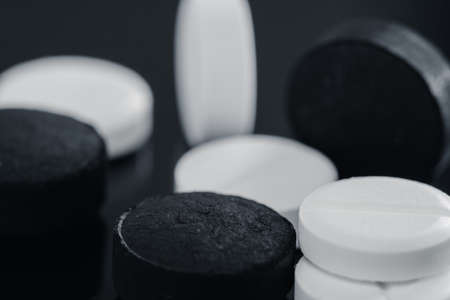 Heap of pills tablets medicine lying isolated on black background extreme close-up macro.の写真素材