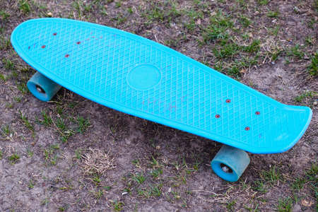 A blue penny board with wheels on grass. Style of freedom and travel in the summer.の写真素材