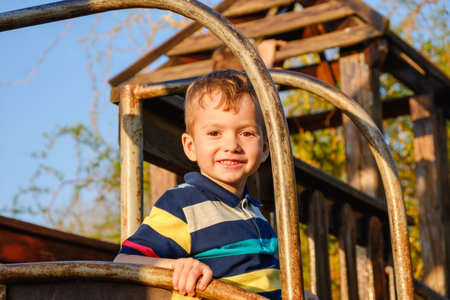 Adorable little 3-4 year old toddler boy having fun on playground, child boy