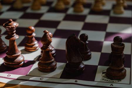 Chess board with pieces and clock on wooden desk In connection with the chess tournament,...