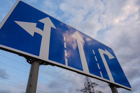 directional road signs close up over blue sky