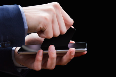 Male hands holding mobile phone with isolated screen and credit card