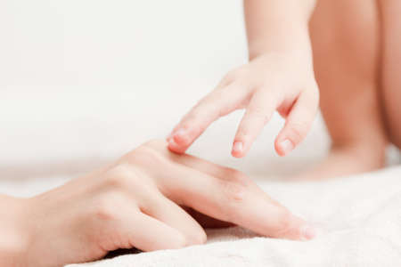 Hands of mother and child. Concept tenderness, motherhood, parenting of children. Isolated on white background.の写真素材
