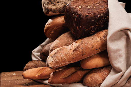 Fresh fragrant bread on the table. Food concept Wheat pastry in textile bag or table clothの写真素材
