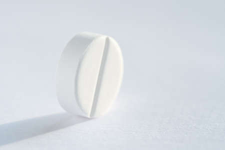 Pill tablet medicine lying isolated on white background extreme close-up macro.の写真素材