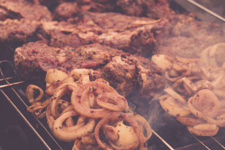 BBQ Roasted Pork Meat With herb spice, onion On Hot Charcoal Grill With Smoke. Backyard Cookout Scene.の写真素材