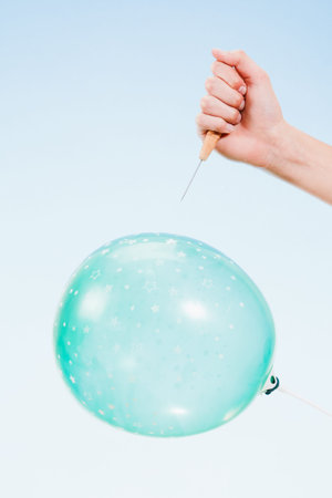 hand holding needle near balloon. isolated on white background. Danger concept.