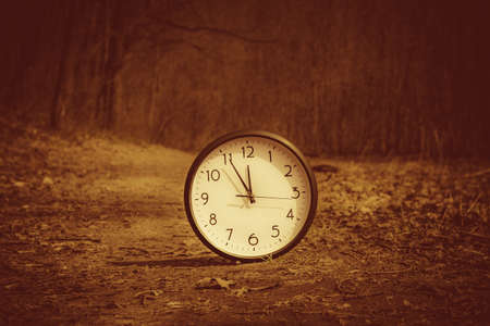 Image of spring Time Change. Summer back concept. Vintage alarm Clock outdoorsの写真素材