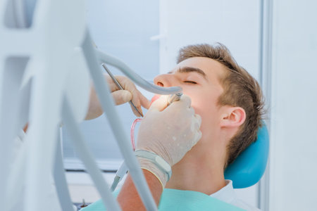 Dental caries prevention.Teenage boy at the dentist's chair during a dental procedure, smile close...