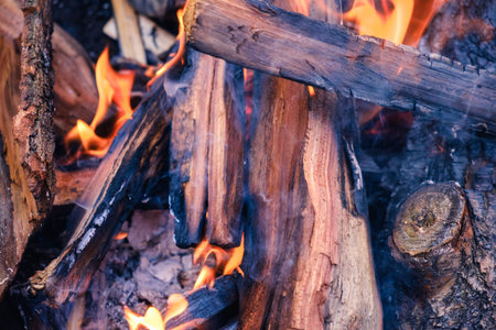Pile of wood cut for fireplace, firewood with fire and smoke