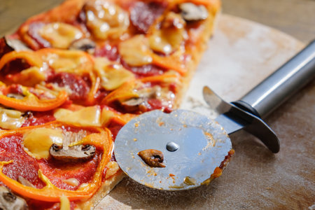 Cutting pepperoni pizza on slices with special knife.
