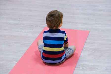 caucasian kid exercising on yoga mats in gym, children sport schoolの写真素材