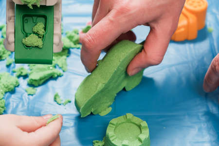 Children playing kinetic colored sand. Kids Games and education in familyの写真素材
