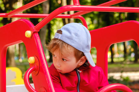Carousel in the park for children. Boy playing on playground.