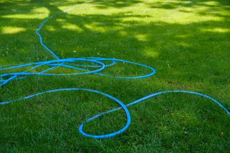 Lawn sprinkler spraying water over green grass, irrigation system.
