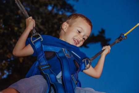 Little boy jumping on the trampoline bungee jumping.