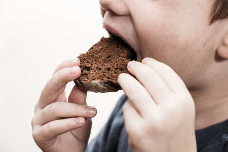 Child beggar eating cheap dirty bread. Poor children and people donations Volunteers Concept.の写真素材