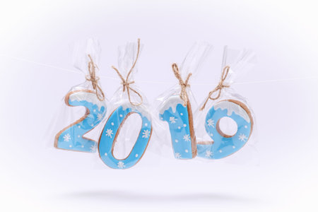 Happy New Year 2019 written with letters and Christmas Decorations Gingerbread cookies on white...