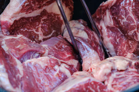 Raw steaks with seasonings. BBQ Barbecue meat on the grillの写真素材