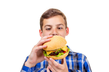 Caucasian boy eating burger and hamburger isolated on white background,  cheese.の写真素材