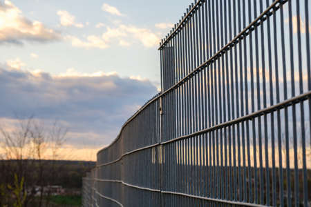 Metal fence wire, painted in green color barrier.の写真素材