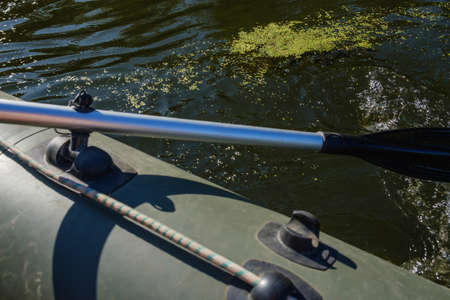 rubber boat, hunter or fisherman man's hand holding paddleの写真素材
